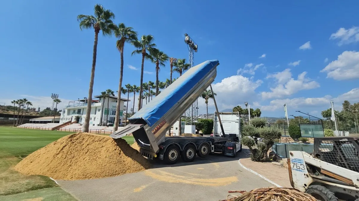 Camión de Transportes JJ García descargando arena en Marbella Football Center
